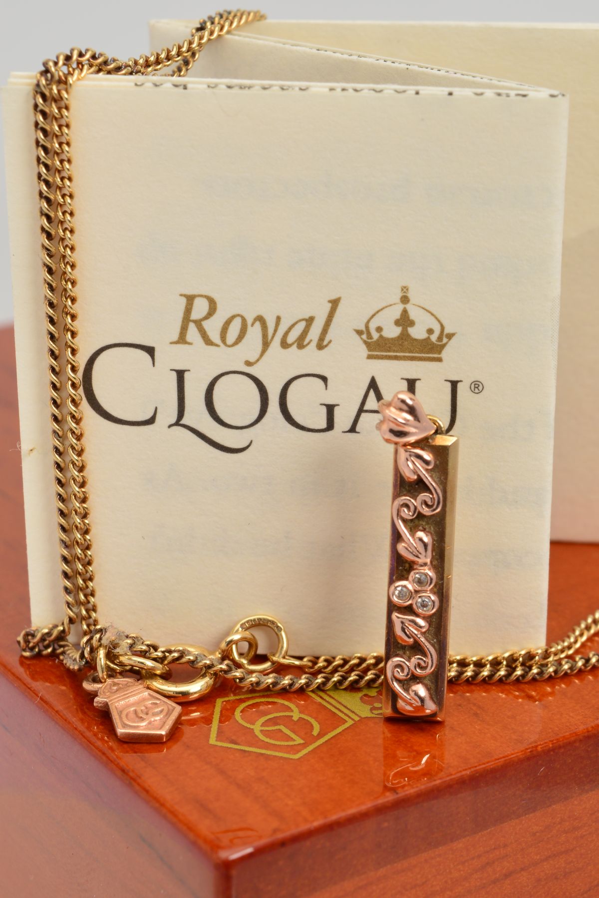 A CASED 9CT GOLD AND DIAMOND CLOGAU PENDANT AND CHAIN, the rectangular pendant centrally set with