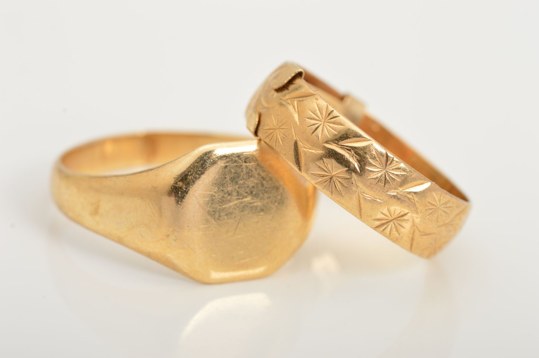 TWO RINGS, to include a signet ring, stamped 9ct, band split, together with a band ring with