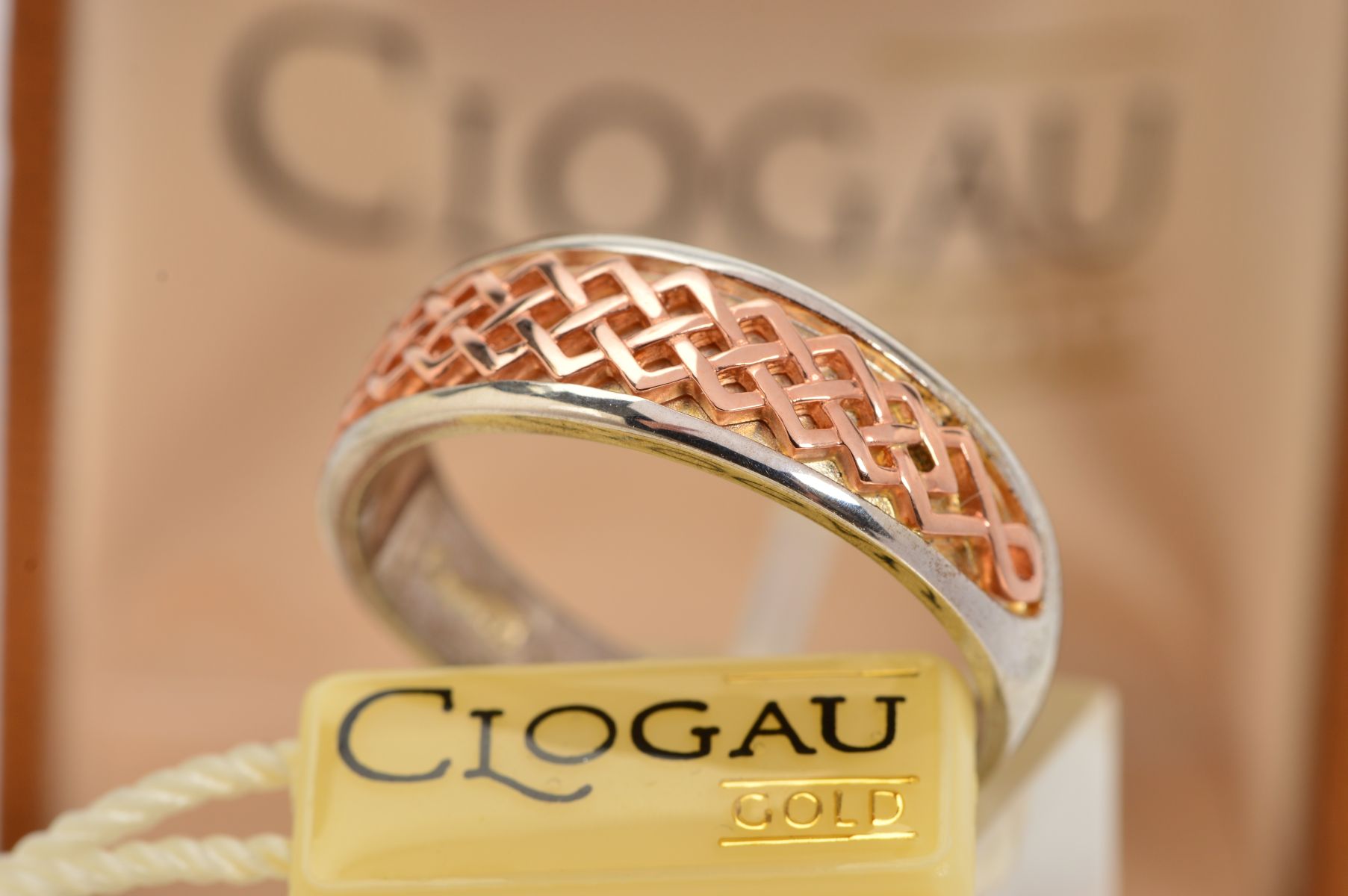 A CASED SILVER AND GOLD CLOGAU RING, designed as a tapered silver band, the front overlaid with a