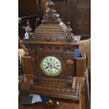 AN EARLY 20TH CENTURY CARVED OAK BRACKET CLOCK, later Smiths movement, the enamel dial with Roman