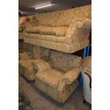 A GOLD FLORAL UPHOLSTERED THREE PIECE LOUNGE SUITE, comprising of a large two seater settee and a