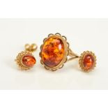 A 9CT GOLD MODIFIED AMBER RING AND EARRINGS, the ring designed with a central oval modified amber