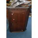 A GEORGIAN OAK HANGING CORNER CUPBOARD with geometric rosettes to single door, width 80cm x depth