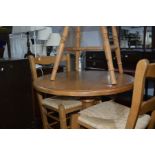 A PINE CIRCULAR KITCHEN TABLE and two rush seated chairs (3)