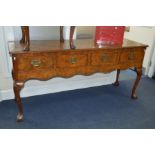 A REPRODUCTION WALNUT DINING SUITE, comprising of an extending table, the top with canted corners on