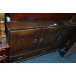 AN ERCOL DARK OAK SIDEBOARD with one large cupboard door to one side and two doors over one long