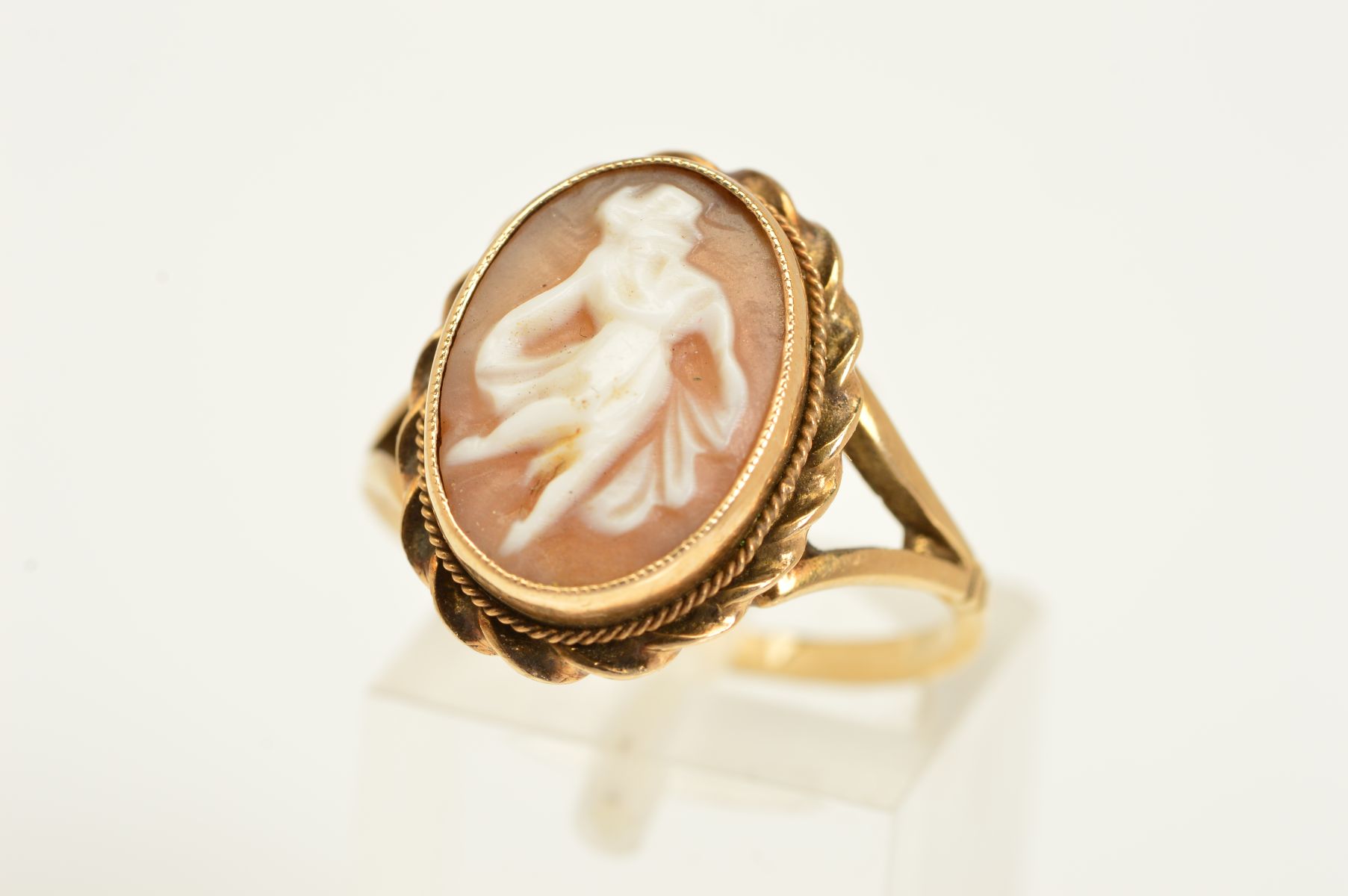 A 9CT CAMEO RING, the oval cameo depicting a dancing female within a rope twist surround, with 9ct