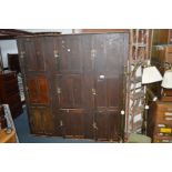 A LATE 19TH/EARLY 20TH CENTURY STAINED PINE SCHOOL LOCKER, made up of nine panelled doors, width