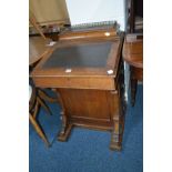 A LATE VICTORIAN OAK DAVENPORT with four drawers and four dummy drawers(sd)