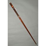 A WOODEN WALKING STICK/PACING STICK, approximate 88cm in length, with metal tip and gold coloured