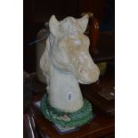 A COMPOSITE BUST OF A HORSES HEAD with a laurel wreath forming a footed base, the painted finish