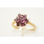 A 9CT GOLD GARNET CLUSTER RING, designed as a garnet tiered cluster ring to the tapered shoulders,