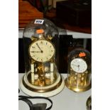 A GERMAN KAISER SKELETON CLOCK UNDER A GLASS DOME, having cream enamelled base and supports to the