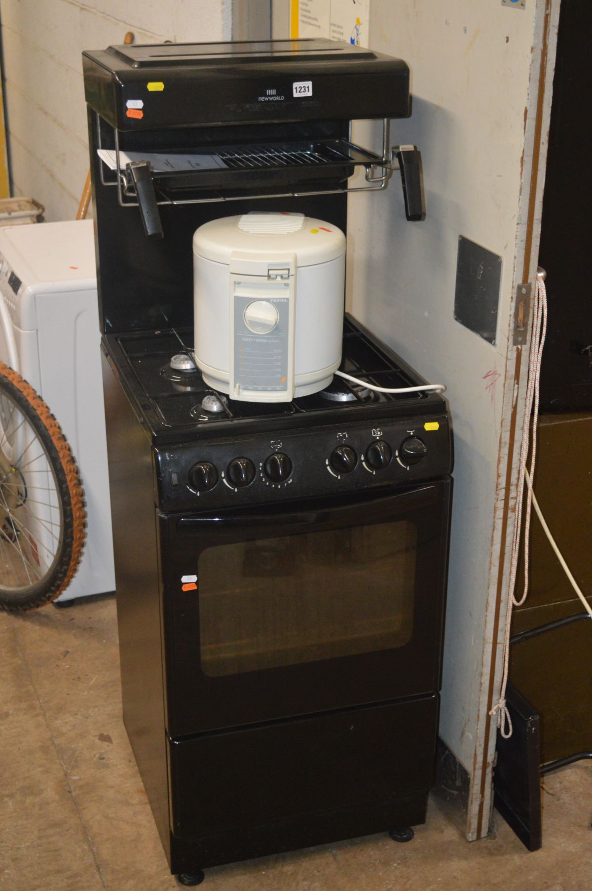 A BLACK NEW WORLD EYE LEVEL GAS COOKER together with a Tefal safety fryer (2)