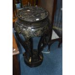 A 20TH CENTURY ORIENTAL BLACK GROUND CIRCULAR TORCHERE STAND on five shape supports, diameter 40cm x