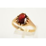 A 9CT GOLD GARNET RING, set with an oval cut garnet in a ten claw setting to the plain polished