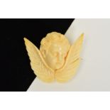 A MID VICTORIAN CARVED IVORY CHERUB BROOCH, carved in relief to depict a cherubs head above a pair