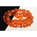 A FACETED AMBER BEAD NECKLACE, designed as oval and spherical faceted amber beads measuring