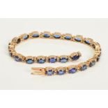A SAPPHIRE AND DIAMOND BRACELET, designed with twenty four oval cut sapphires each interspaced