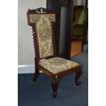 A VICTORIAN WALNUT PRAYER CHAIR, the back with a foliate carved top rail and flanked by barley twist