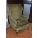 AN EARLY 20TH CENTURY WINGBACK ARMCHAIR WITH CLAW FRONT LEGS