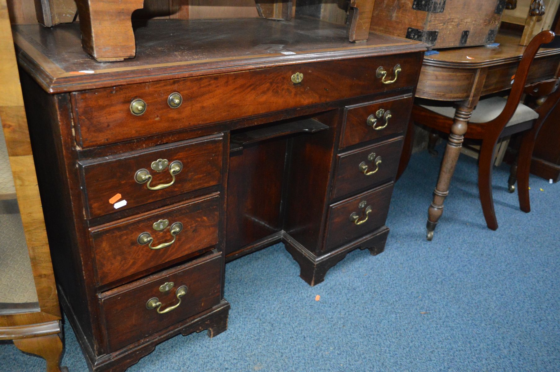 AN EARLY 20TH CENTURY GEORGIAN STYLE MAHOGANY KNEE HOLE DESK with a brown leather insert, one long