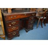 AN EARLY 20TH CENTURY GEORGIAN STYLE MAHOGANY KNEE HOLE DESK with a brown leather insert, one long