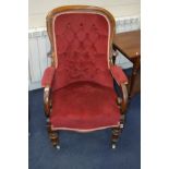 A VICTORIAN WALNUT SCROLLED ARMCHAIR on turned front legs and ceramic casters