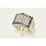 A DIAMOND AND SAPPHIRE RING, a tiered rectangular panel set with four rows of brilliant cut diamonds