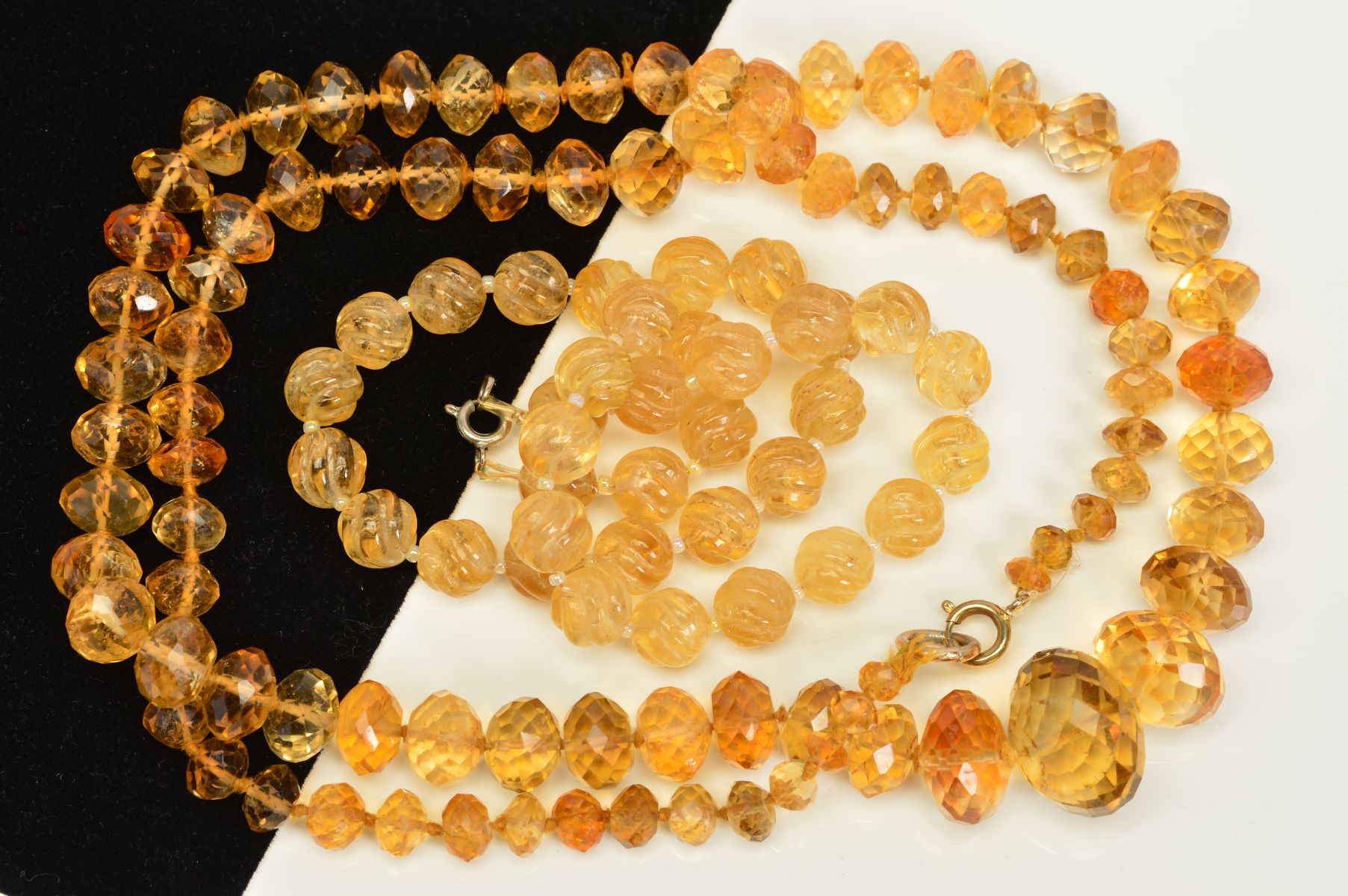 TWO CITRINE BEAD NECKLACES, the first designed as a uniform single row of carved spherical beads,