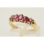 A FIVE STONE GARNET RING, designed as a graduated row of five oval and circular garnets within