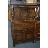A BEVAN FUNNELL REPRODUX NARROW CARVED OAK COURT CUPBOARD with turned supports and single cupboard