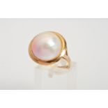 A MABE PEARL RING, designed as a mabe pearl within a plain surround to the bifurcated shoulders,