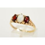 A 9CT OPAL AND RUBY RING, designed with a central oval opal cabochon flanked either side with an