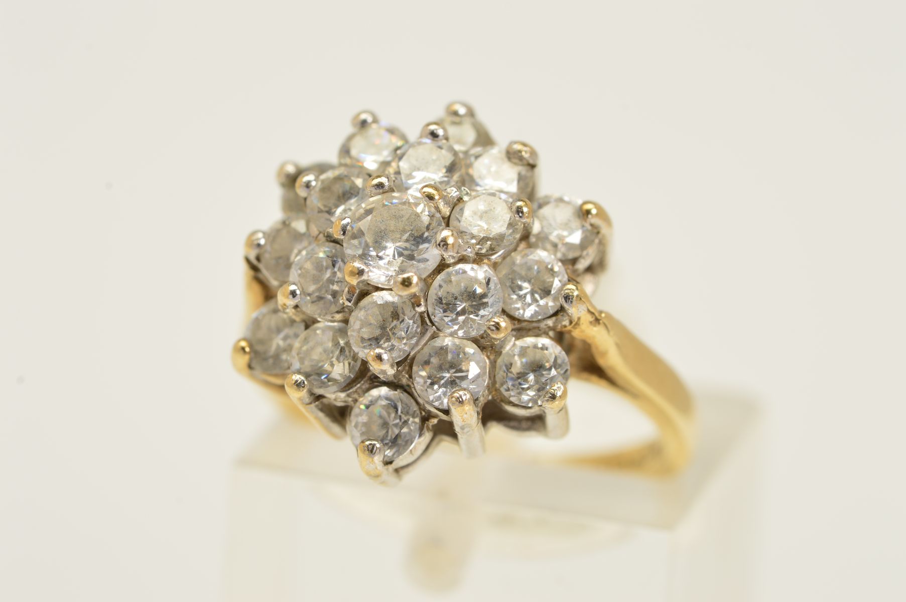 A 9CT GOLD CLUSTER RING, designed as a tiered cluster of circular colourless pastes, with 9ct