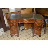 A BEVAN FUNNEL REPRODUCTION MAHOGANY SERPENTINE KNEE HOLE DESK, with a green tooled leather top, one