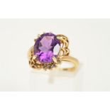 A 9CT GOLD AMETHYST RING, designed as an oval amethyst within a four claw setting, to the part