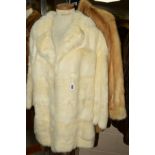 A LADIES BEIGE MINK THIGH LENGTH COAT, having stand up collar, fitted cuffs and side-seam pockets,