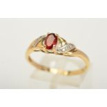 A 9CT GOLD GARNET AND DIAMOND RING, designed with a central oval cut garnet flanked with three