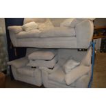 A CREAM UPHOLSTERED FOUR PIECE SUITE comprising of a two seat settee, two arm chairs and a pouffe (