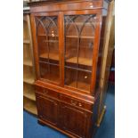 A YEWWOOD GLAZED TWO DOOR BOOKCASE with two drawers, width 99cm x depth 37cm x height 194cm,