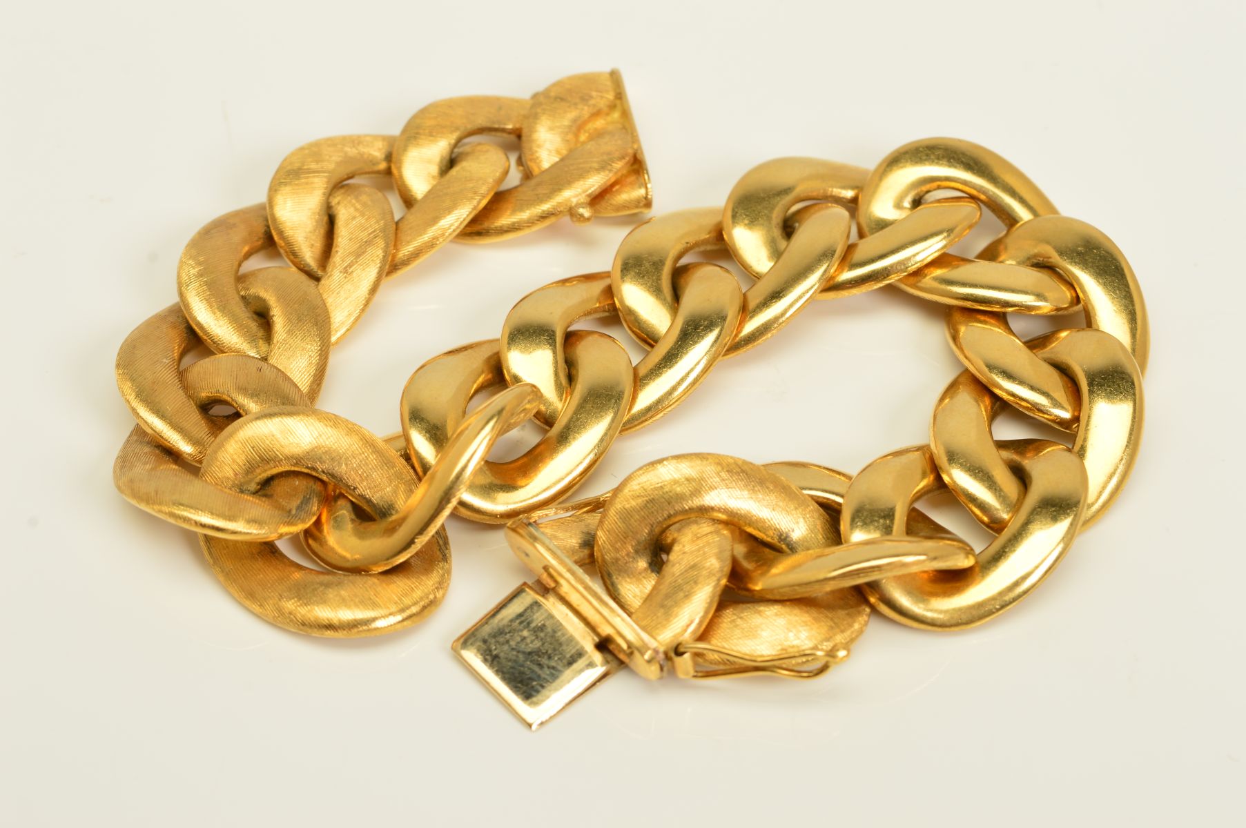 AN ITALIAN BRACELET BY CHIAMPESAN, of a wide curb link design, the links with a textured finish to