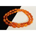 A NATURAL AMBER NECKLACE, designed as graduated oval shape beads measuring 8mm to 16mm, to the screw