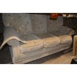 A FLORAL UPHOLSTERED BEIGE THREE SEATER SETTEE