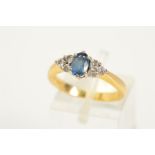 AN 18CT GOLD SAPPHIRE AND DIAMOND RING, designed with a central oval cut sapphire flanked with three