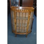 AN EARLY 20TH CENTURY HALF MOON WALNUT CHINA CABINET with single door and ball and claw cabriole