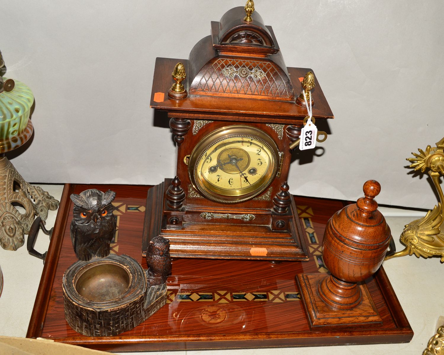 A MANTEL CLOCK, Arabic numerals, dial distressed, with key and pendulum, a carved 'owls' ashtray,