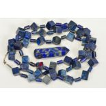 A LONG LAPIS LAZULI BEAD NECKLACE AND A LAPIS LAZULI PAPERWEIGHT, the necklace designed as cube