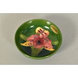 A SMALL MOORCROFT POTTERY FOOTED BOWL, 'Orchid' pattern on green ground, impressed marks to base and