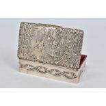 AN EDWARDIAN SILVER TRINKET BOX OF RECTANGULAR FORM, the hinged lid repousse decorated with a fete